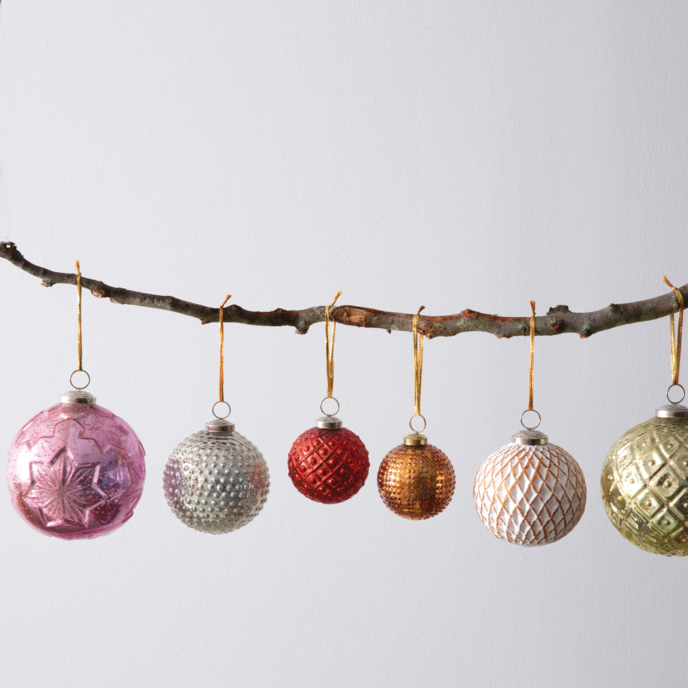 Four pink mercury glass ornaments with a snowflake pattern, each with a gold tie, displayed in a decorative box. View 2