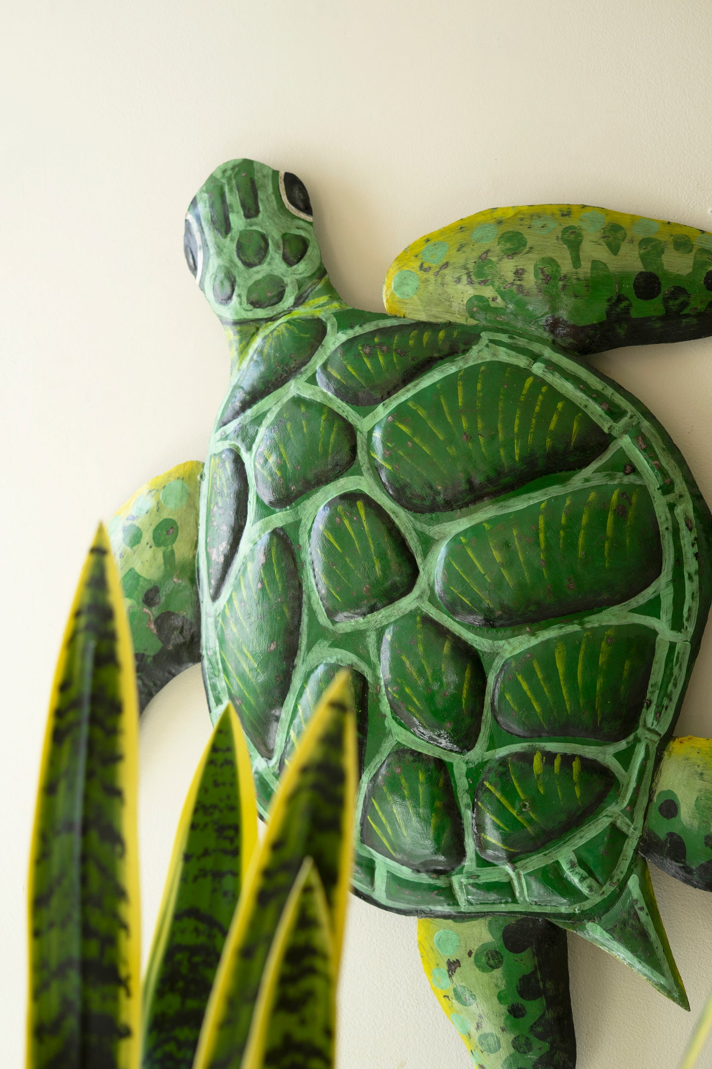 Sea turtle wall sculpture made from recycled metal with a hammered texture, showcasing a sweeping silhouette for coastal decor.