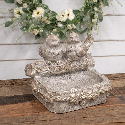 Distressed stone-look bird feeder with floral accents, featuring two carved birds on a log, in dimensional gray tones.