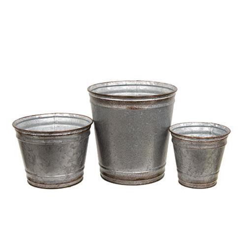 Set of three round galvanized silver metal planters with distressed copper edges, filled with vibrant plants on a porch.