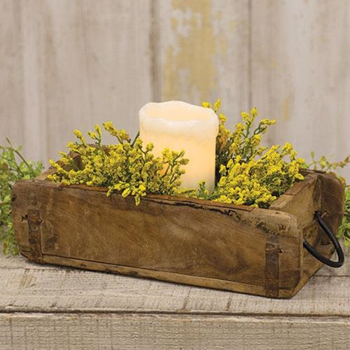 Rustic wooden brick mold with two black metal handles, unpainted finish, styled as a planter with florals on a flat surface.
