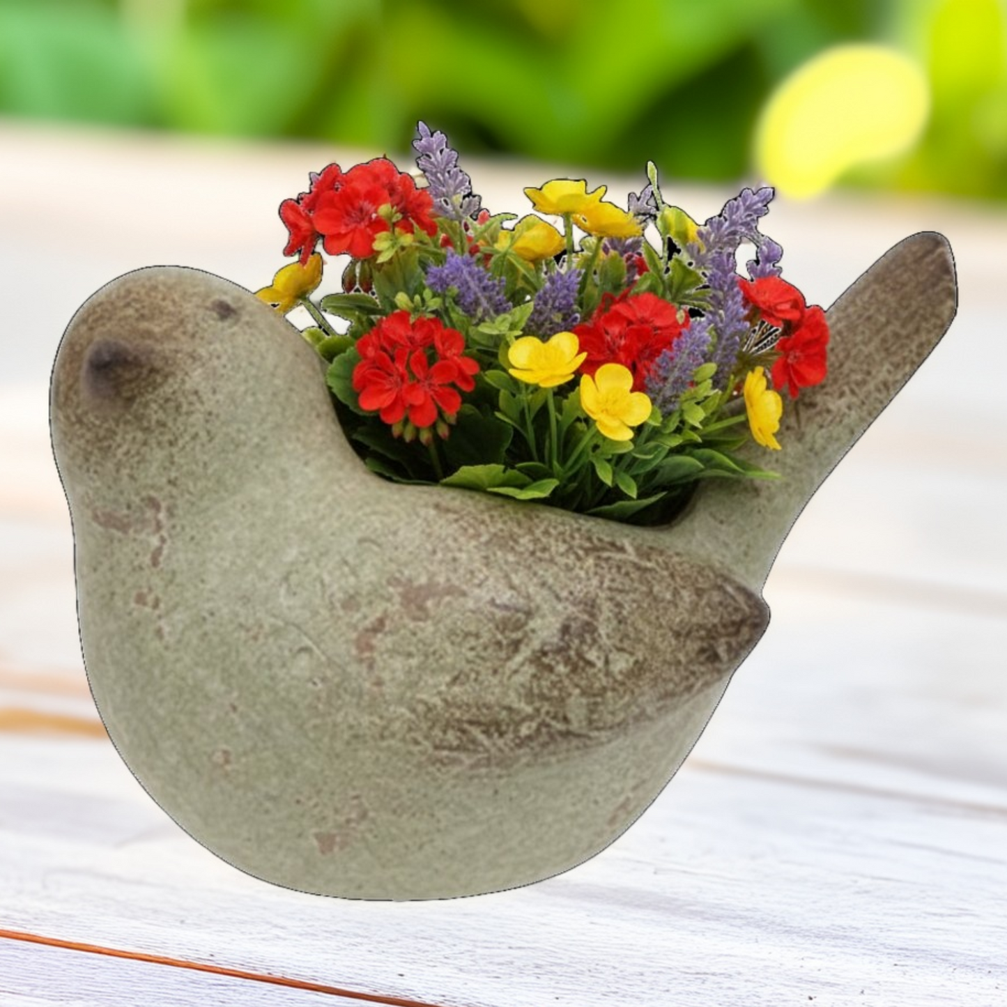 Bird-shaped planter with colorful flowers on a wooden surface