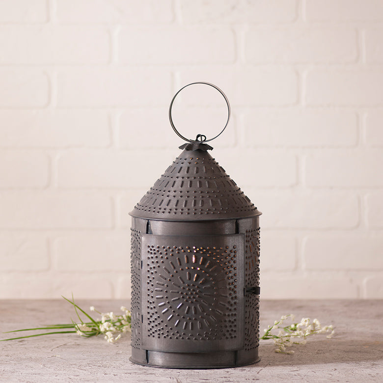 Revere Lantern with intricate punch pattern casting a warm glow, enhancing home decor with charm and ambiance.