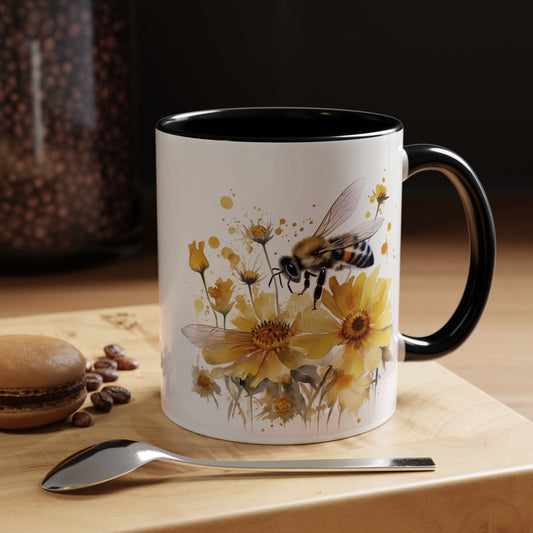 White ceramic mug with black handle and golden bee wildflower watercolor design