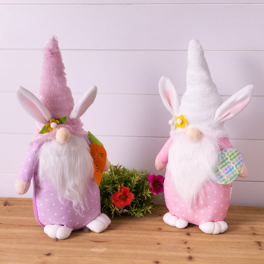 Two plush Easter bunny gnomes in pastel pink and purple with bunny ears, sitting on a shelf, adding whimsy to spring decor.