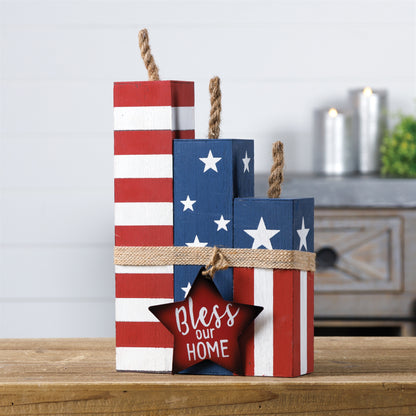 Three rustic wooden blocks in red, white, and blue with "Bless this Home" text, perfect for patriotic decor.