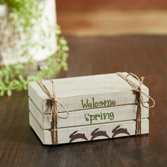 Cream faux book stack decor with Welcome Spring text, hand-painted bunnies, and soft farmhouse spring charm.