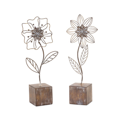 Metal floral decor with intricate flower design on a distressed white-washed base, featuring rustic brown and white tones.