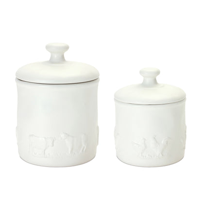 White ceramic canisters with farm animal accents, featuring chickens and cows, perfect for a farmhouse-style kitchen.