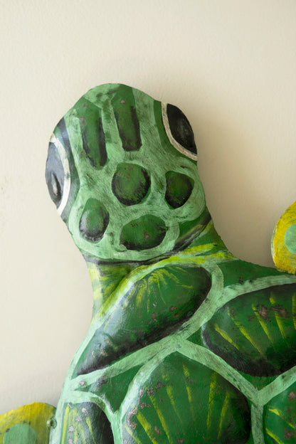 Sea turtle wall sculpture made from recycled metal with a hammered texture, showcasing a sweeping silhouette for coastal decor.