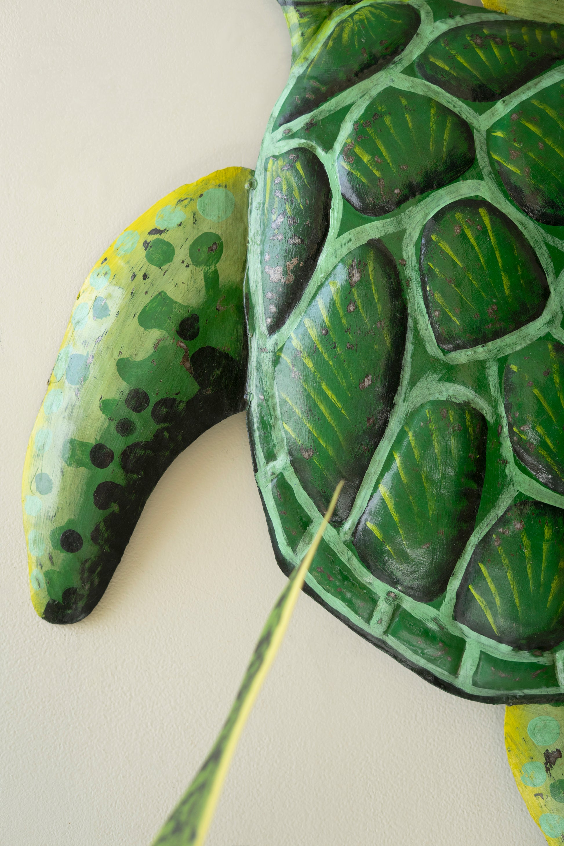 Sea turtle wall sculpture made from recycled metal with a hammered texture, showcasing a sweeping silhouette for coastal decor.