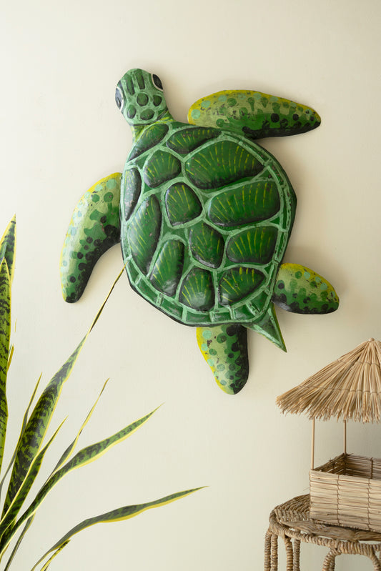 Sea turtle wall sculpture made from recycled metal with a hammered texture, showcasing a sweeping silhouette for coastal decor.