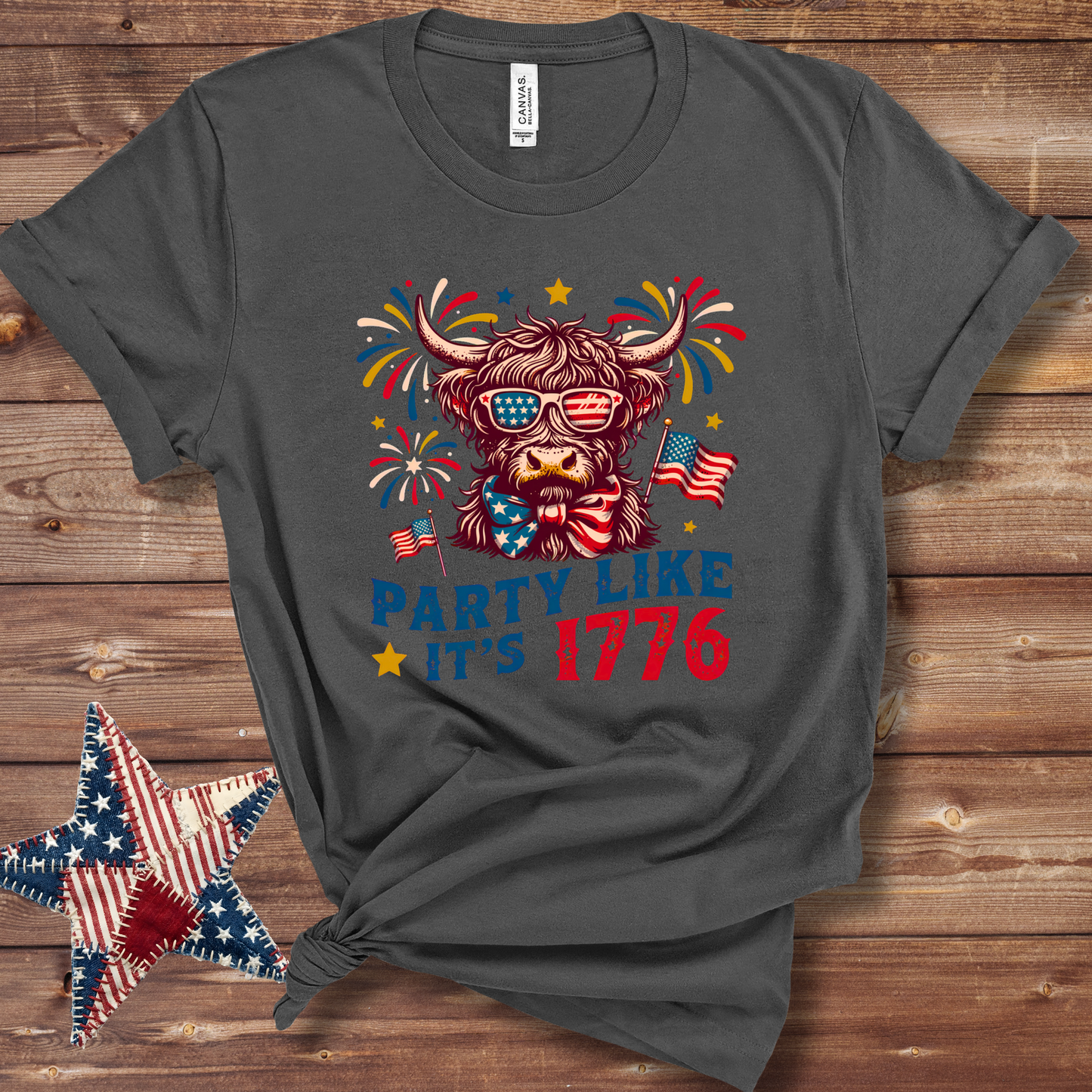Grey Patriotic Highland cow graphic T-shirt with stars-and-stripes bandana in red, white, and blue for Fourth of July fun