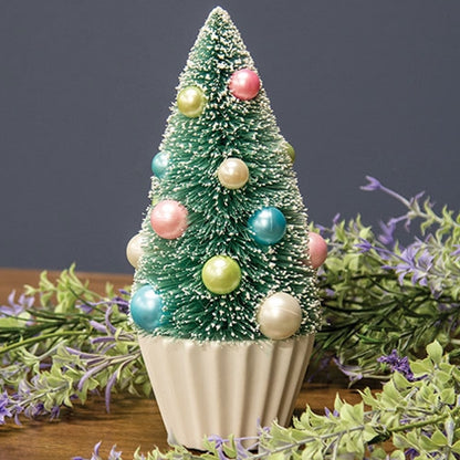 Teal bottle brush tree with faux snow, pastel pearl baubles in blue, pink, green, white on a pleated white base.