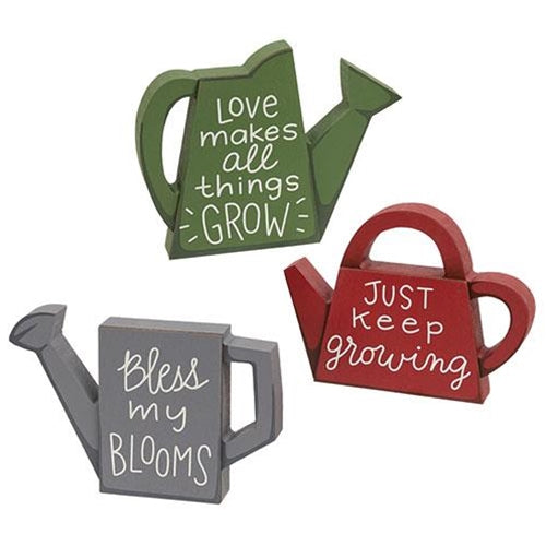 Three colorful wooden watering can sitters with inspiring messages, perfect for adding a whimsical touch to any space.