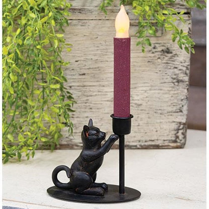 Black iron taper candle holder with a playful sitting cat figurine, perfect for adding whimsy to tabletops or mantles.