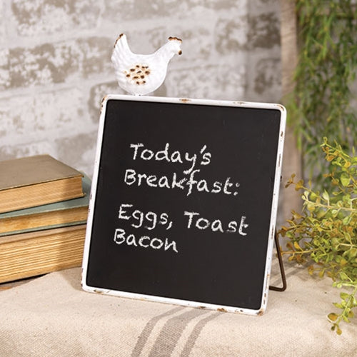 Farmhouse-style chalkboard sign with distressed white metal frame and chicken figurine, supported by a metal easel kickstand.