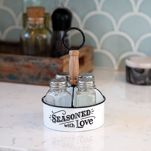 Rustic white metal seasoning caddy with wood handle and four glass shakers, featuring “seasoned with love” lettering