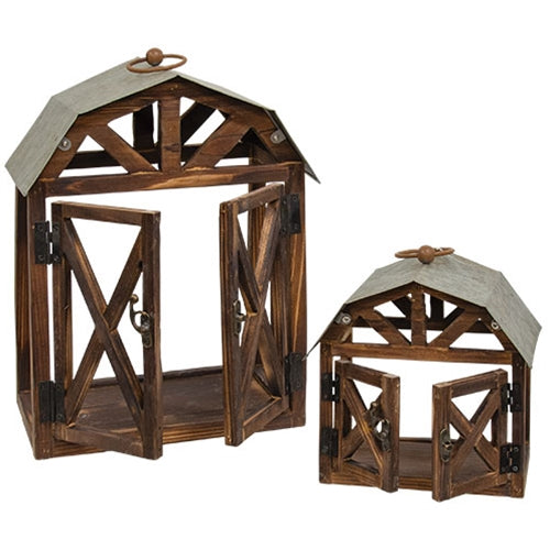 Rustic wood and metal barn-shaped lanterns with open sides, detailed roofs, and swinging doors, perfect for decor.
