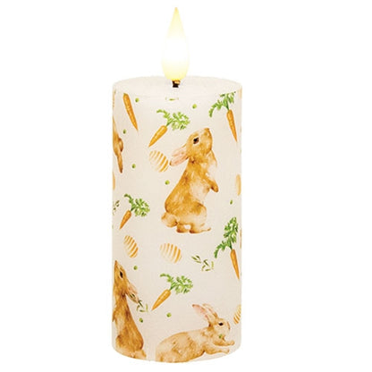 Carrot Top Pillar candle with faux flame, featuring bunnies, carrots, and eggs pattern, creating a cozy, whimsical atmosphere.