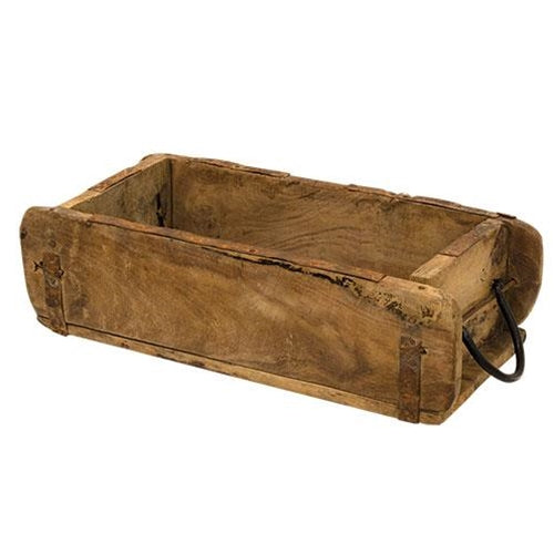 Rustic wooden brick mold with two black metal handles, unpainted finish, styled as a planter with florals on a flat surface.