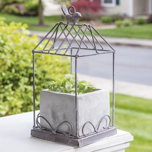 Graywash metal birdcage with cement planter, featuring a bird finial and loop for hanging, perfect for floral displays.
