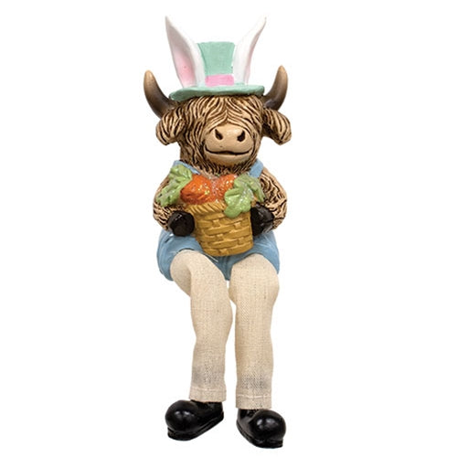 Highland cow figurines in pastel overalls and hats, with dangling fabric legs, holding Easter-themed items like eggs and carrots.