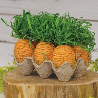 Egg crate with six orange paper carrots and green paper grasses, set on dried straw, perfect for spring decor.