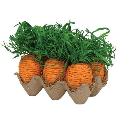 Egg crate with six orange paper carrots and green paper grasses, set on dried straw, perfect for spring decor.