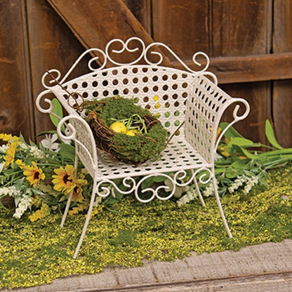 Cream-colored metal garden chair planter stand with lattice design, vintage style, and swirling flourishes on curved legs.