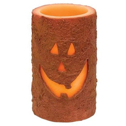 Battery-operated LED jack-o'-lantern pillar candle with grungy wax finish and warm Halloween glow
