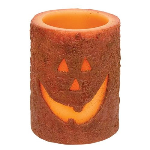 Jack-O'-Lantern LED pillar candle with grungy wax finish, glowing carved pumpkin face, cozy Halloween decor
