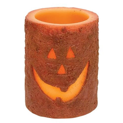 Jack-O'-Lantern LED pillar candle with grungy wax finish, glowing carved pumpkin face, cozy Halloween decor