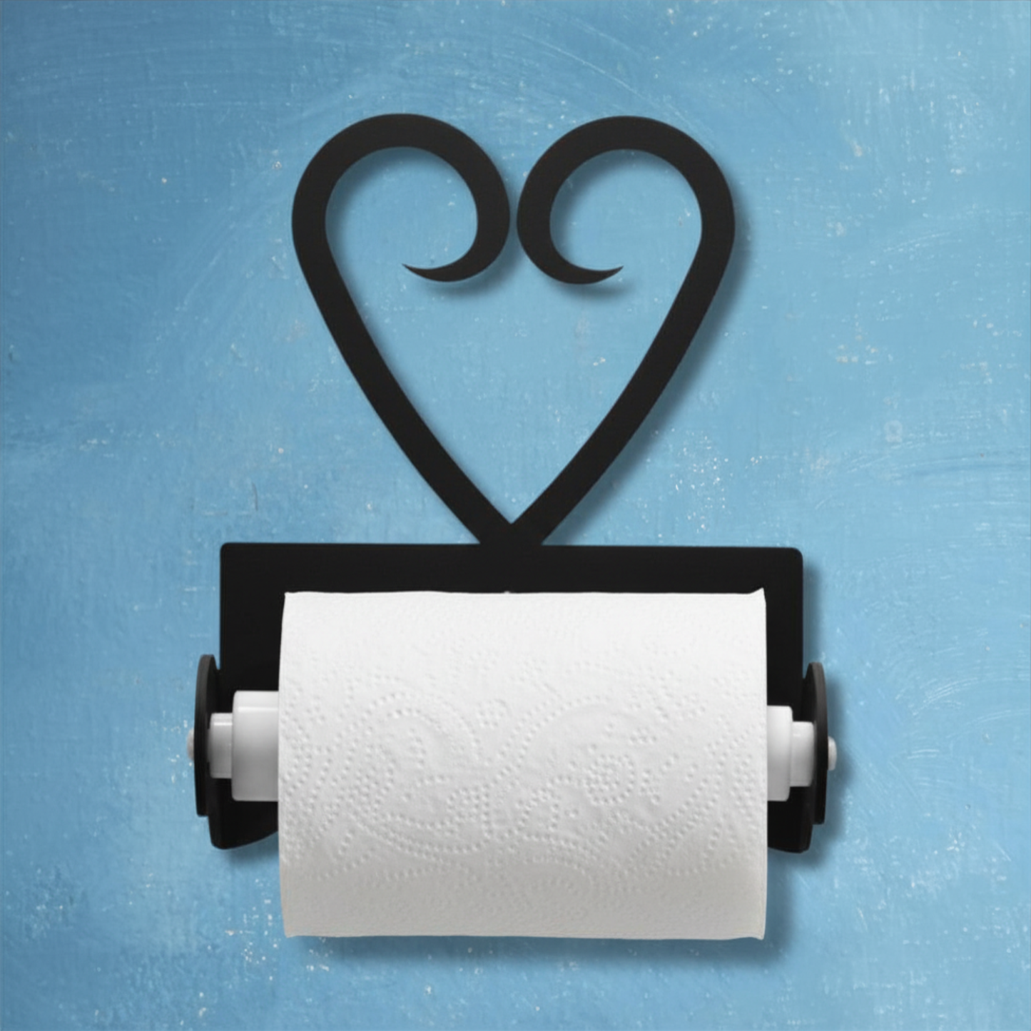 Black heart-shaped paper towel holder with a roll of white paper towels on a blue background