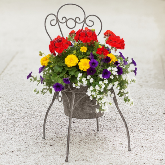 Decorative metal chair with a colorful flower arrangement on a grassy background