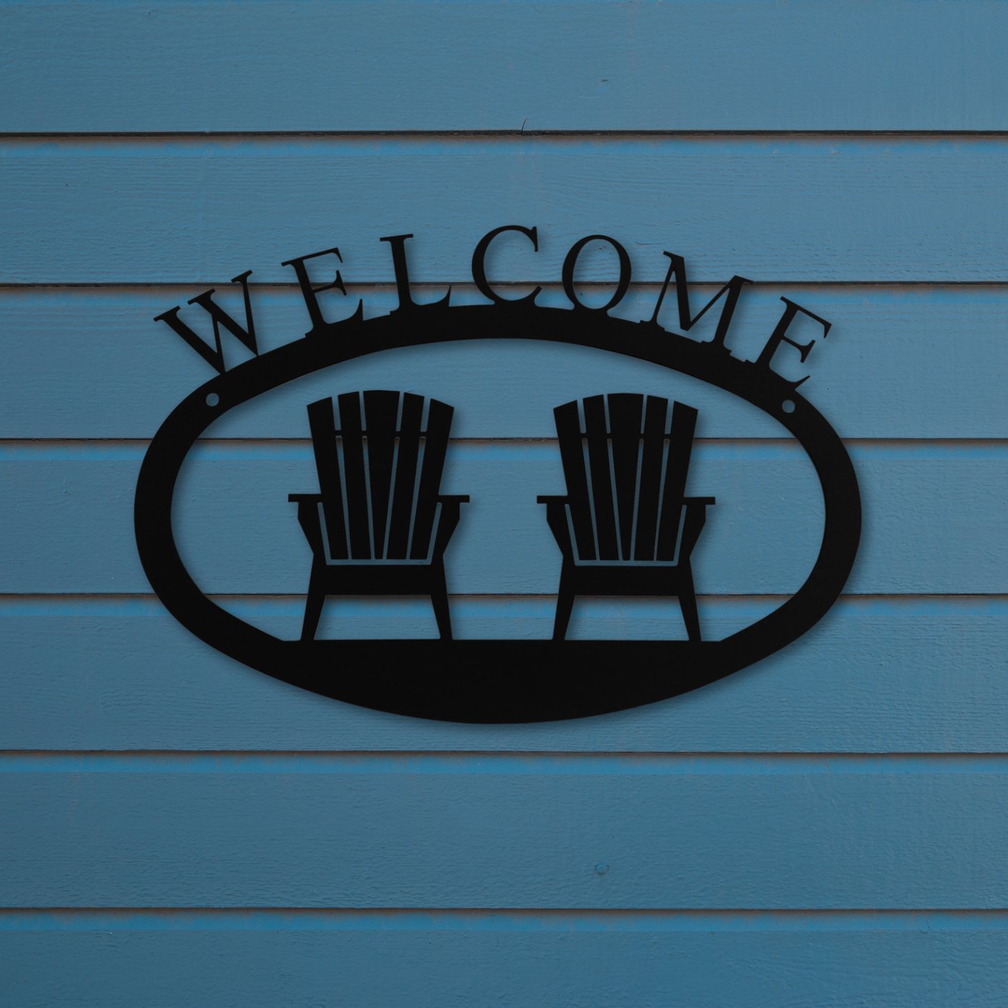 Metal 'Welcome' sign with two chairs on a blue wooden background