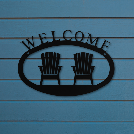 Metal 'Welcome' sign with two chairs on a blue wooden background