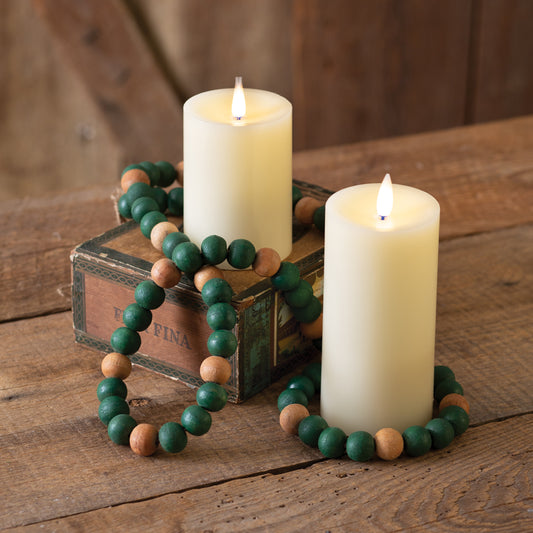 Green and tan decorative wood beads draped elegantly on a two-tier tray, adding festive charm to a cozy home setting.